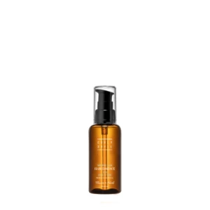 Tall amber glass spray bottle with a black pump dispenser and clear cap, showing a white label with product name 'Hair Essence' and 'Moisture Glow' text.