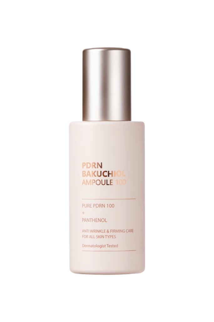 Close-up of a light pink pump bottle with a metallic silver pump, label shows 'PDRN BAKUCHIOL AMPOULE 100' against a black background