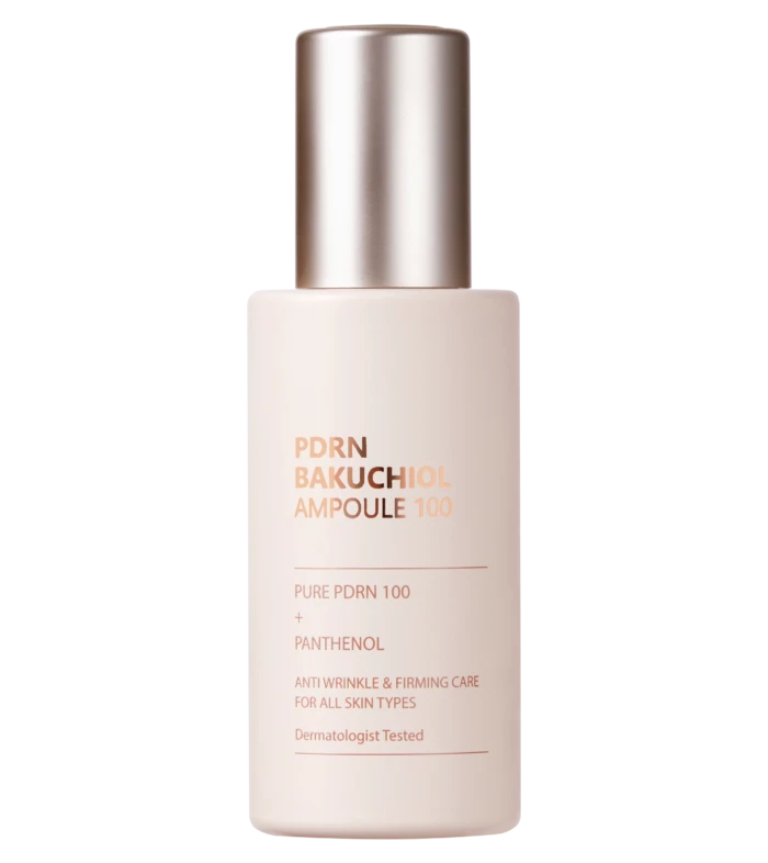 Close-up of a light pink pump bottle with a metallic silver pump, label shows 'PDRN BAKUCHIOL AMPOULE 100' against a black background