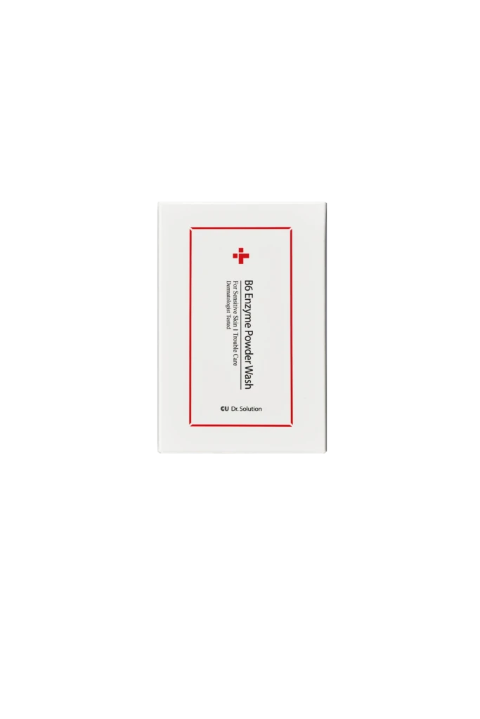 White cardboard box displaying product label: B6 Enzyme Powder Wash with red border and small cross logo at the top center (cosmetic item).