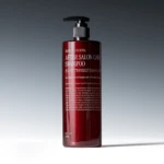Red pump bottle of After Salon Care Shampoo with visible label on a gray gradient backdrop.