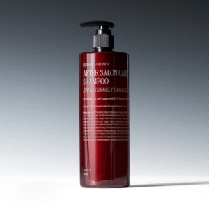 Red pump bottle of After Salon Care Shampoo with visible label on a gray gradient backdrop.