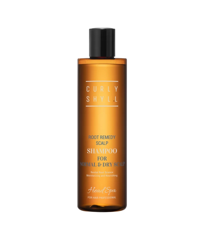 Orange shampoo bottle with a black cap, label reads 'Root Remedy Scalp Shampoo' for normal and dry scalp against a white background in a close-up shot.
