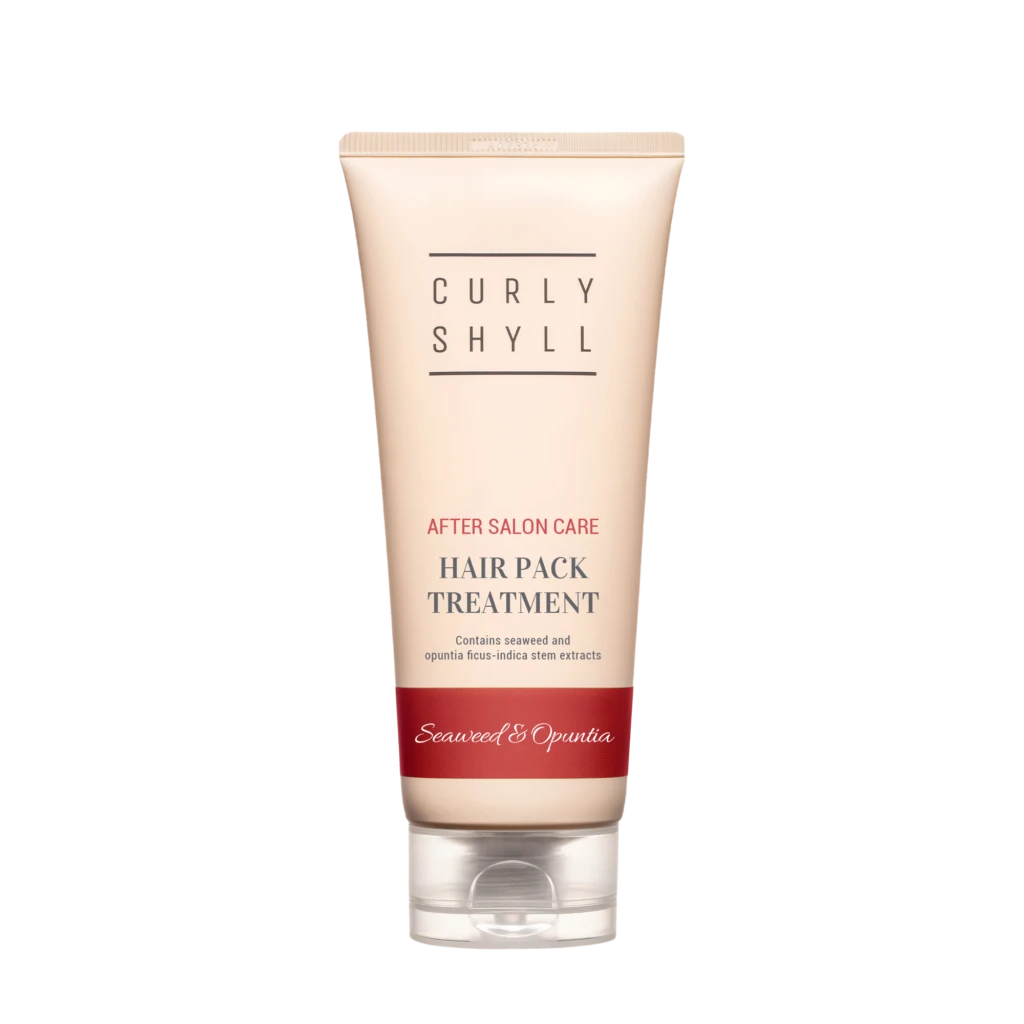 Tube of hair treatment product labeled Curly Shyll with 'After Salon Care' and 'Hair Pack Treatment' text in a pale pink container against a light background.