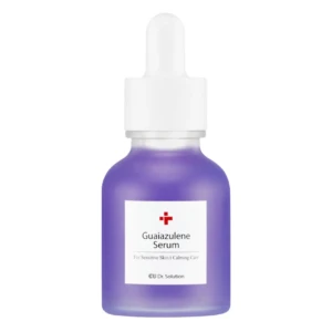 Purple glass serum bottle with a white dropper cap and label reading 'Guaiazulene Serum'
