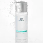 Tall skincare toner bottle labeled 'CU CLEAN-UP' with water splashing around the top and sides, creating a dynamic splash scene.