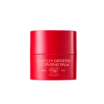 Red cylindrical cosmetic bottle with bold white text: CAMELLIA GRINDING CLEANSING BALM (vegan formula) on black background. Signs of floral logo beneath.