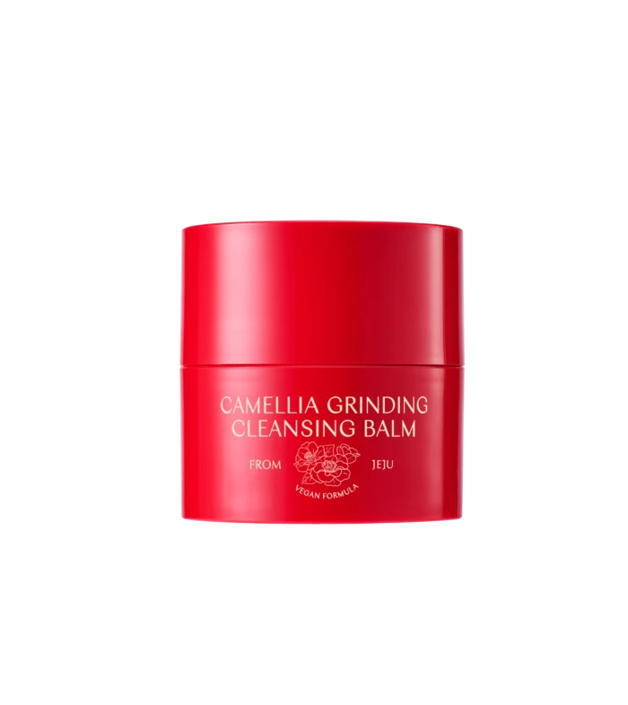 Red cylindrical cosmetic bottle with bold white text: CAMELLIA GRINDING CLEANSING BALM (vegan formula) on black background. Signs of floral logo beneath.