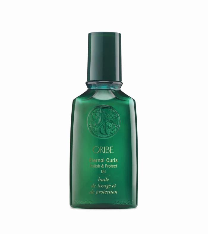 Close-up of a tall, dark green bottle with a long neck against a white background; embossed emblem on the front.