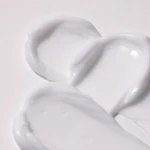 Three dollops of thick white cream on a white background.