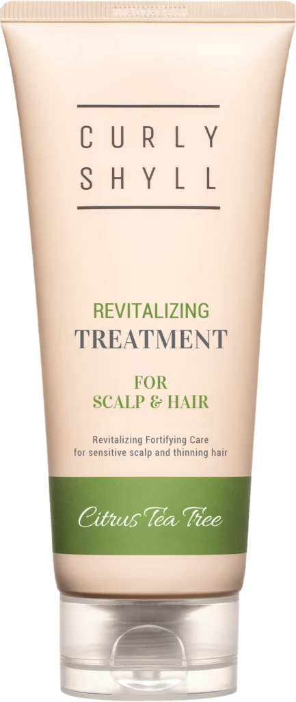 Beige tube of Curly Shyll revitalizing treatment for scalp and hair with a green Citrus Tea Tree band and beige cap.