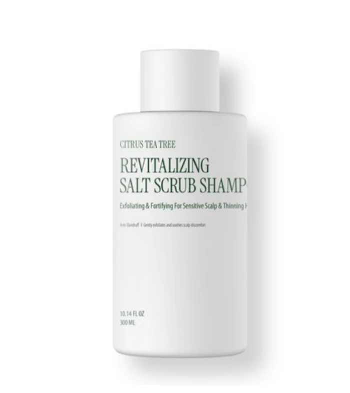 White bottle labeled "Revitalizing Salt Scrub Shampoo" with Citrus Tea Tree on a white background, cosmetic product.