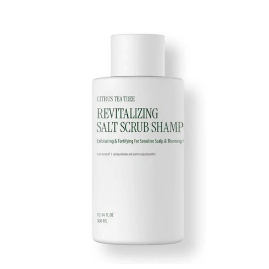 White bottle labeled "Revitalizing Salt Scrub Shampoo" with Citrus Tea Tree on a white background, cosmetic product.
