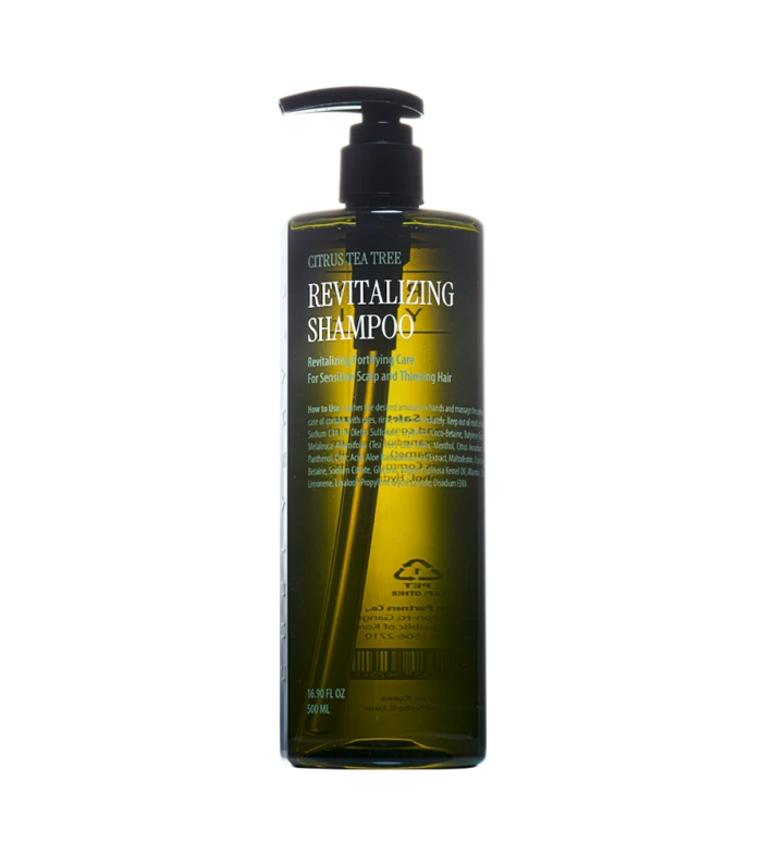 Bottle of revitalizing shampoo with pump dispenser labeled 'Revitalizing Shampoo' and citrus-tea tree design on dark green bottle