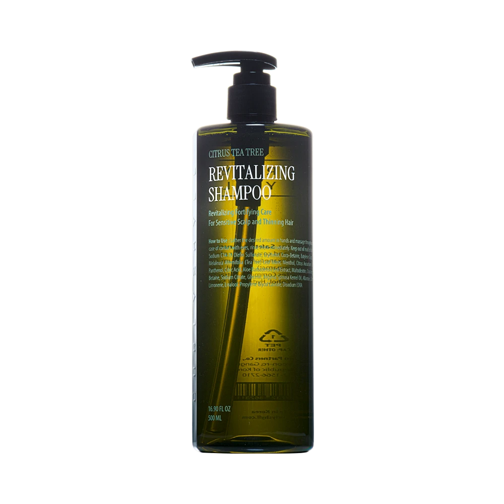 Bottle of revitalizing shampoo with pump dispenser labeled 'Revitalizing Shampoo' and citrus-tea tree design on dark green bottle